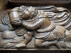 A monk takes a drink (with some enthusiam): 16th C. misericord, the Collegiate Church of Notre-Dame (Collégiale Notre-Dame), Le Puy-Notre-Dame, Anjou, France