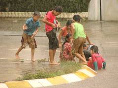 Children Play in Monsoon Downpour - Pakse - Laos Children Play in Monsoon Downpour - Pakse - Laos