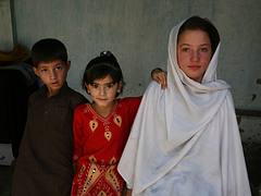 A student supported by Hashoo Foundation in a school in Chitral sits next to her niece and nephew in their house.